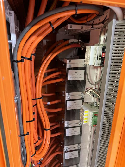 Orange power cabling run into a data centre control cabinet