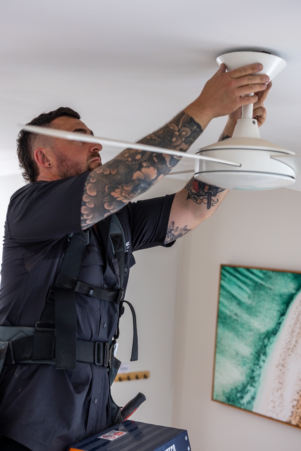 Ceiling fan being fitted to a new mounting point