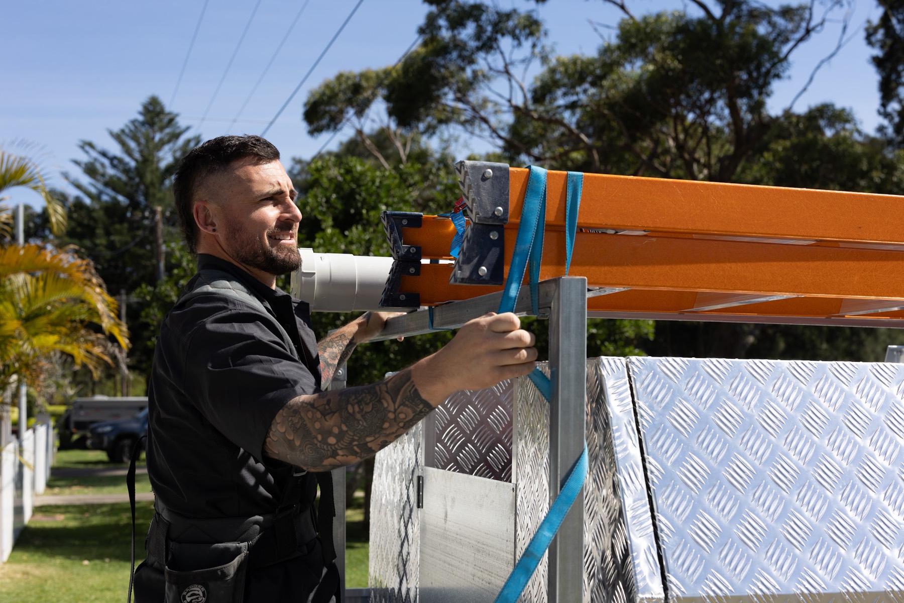 Vincent unstrapping a ladder from the roof rack on site