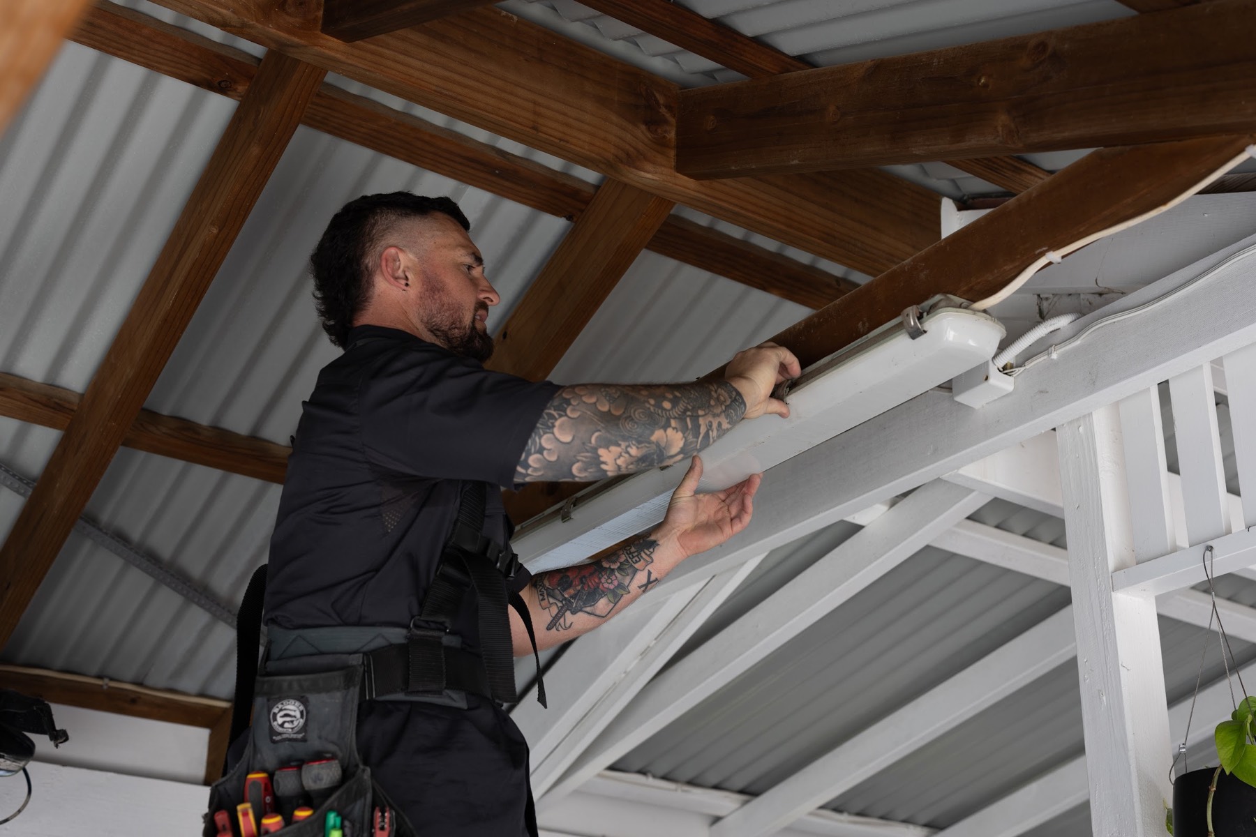 Vincent installing a new light fitting under a carport