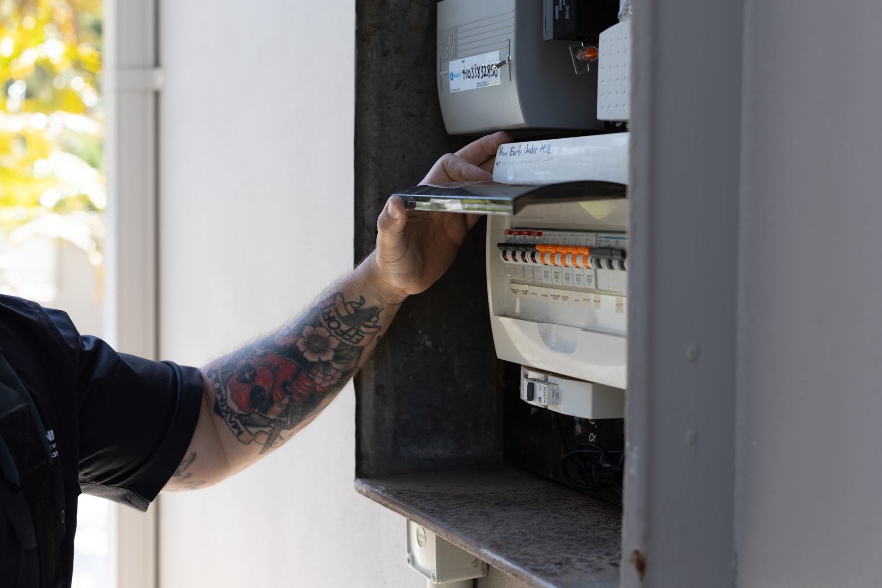 Checking breakers and labelling inside a switchboard during a property electrical assessment