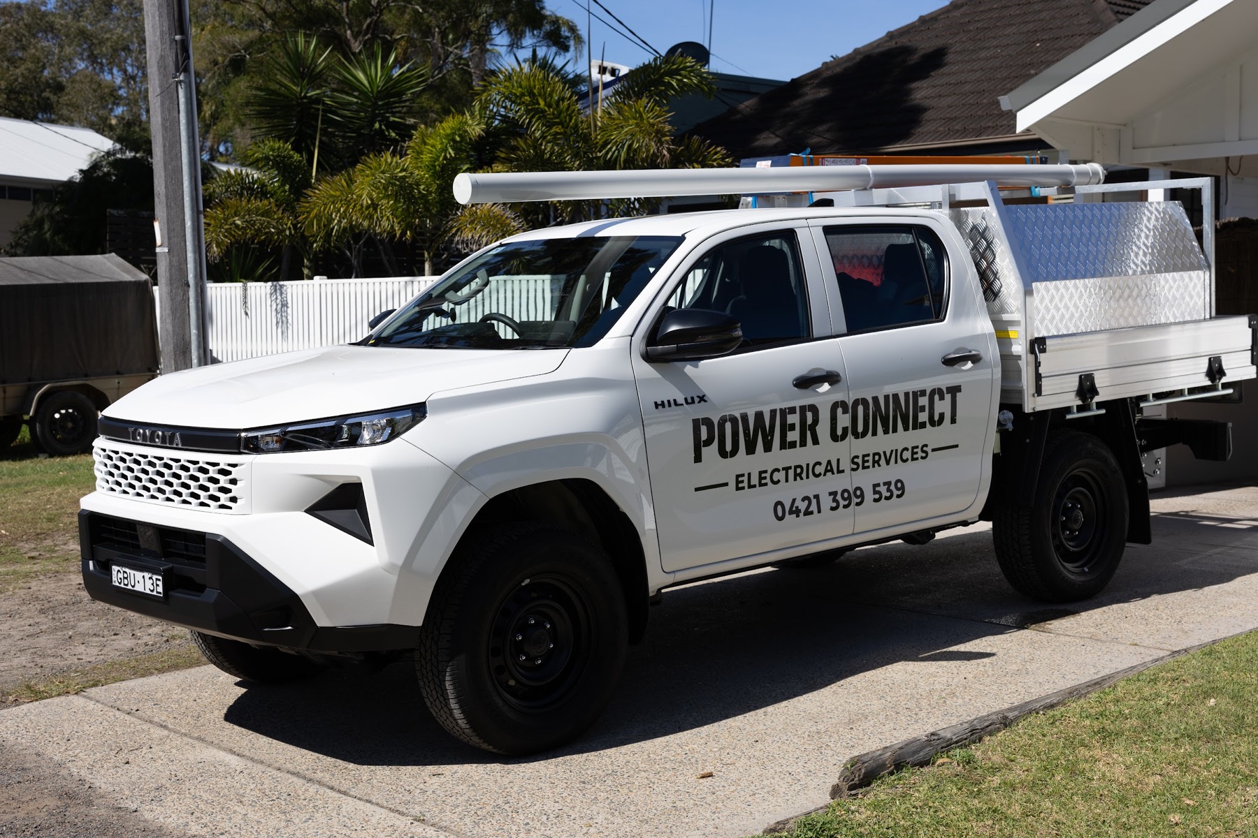 The signwritten Power Connect ute parked outside a Northern Beaches home